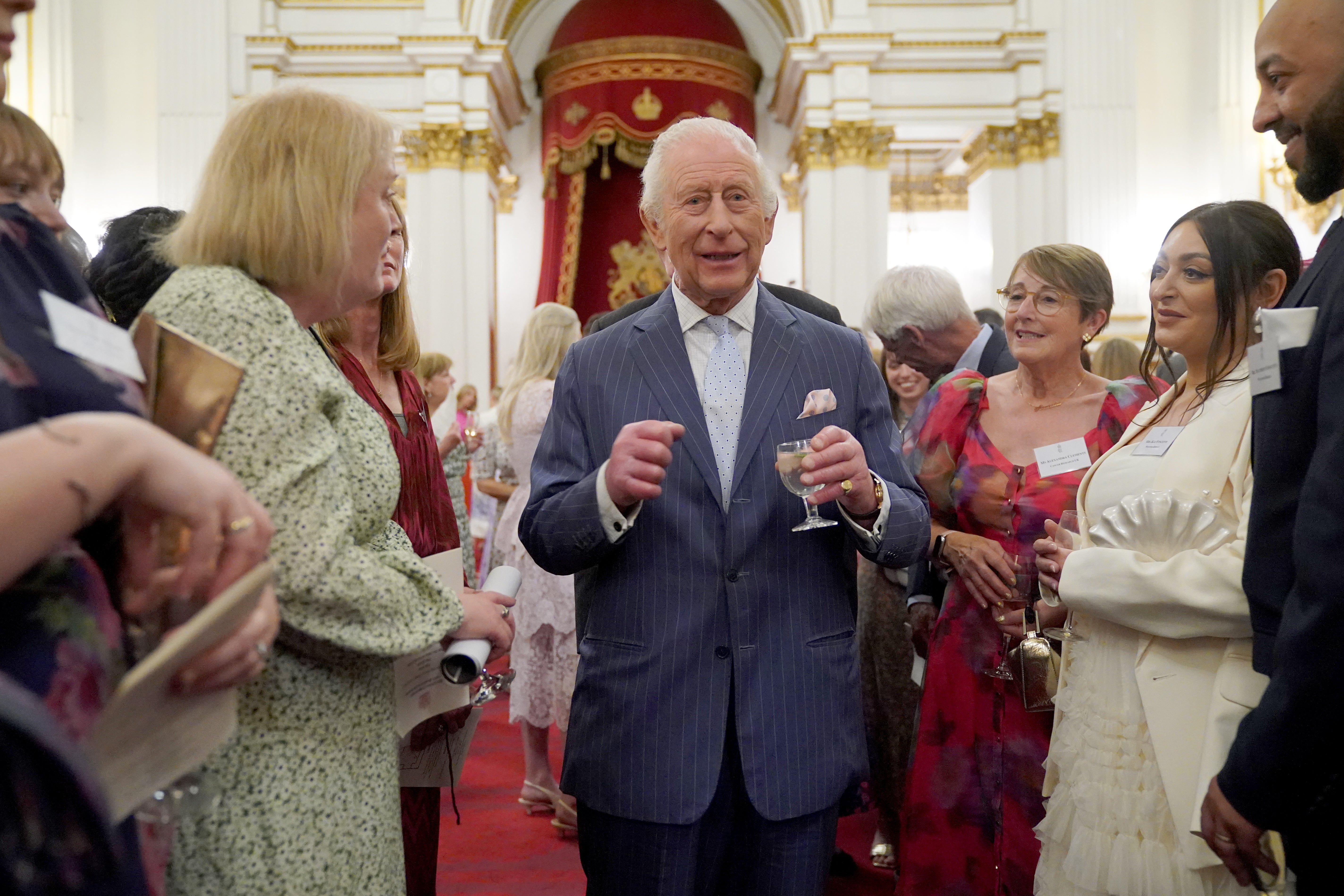 King Charles speaks to guests during a reception in Buckingham Palace