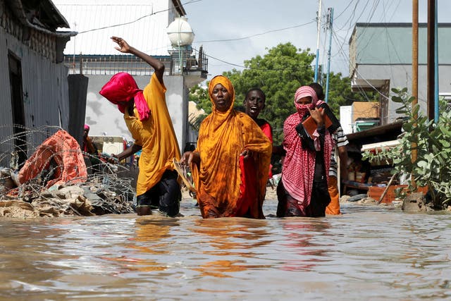 <p>A Somali family wades through flood waters as they flee after overnight rains destroyed their home, in Wadajir district of Mogadishu, Somalia, earlier this month</p>