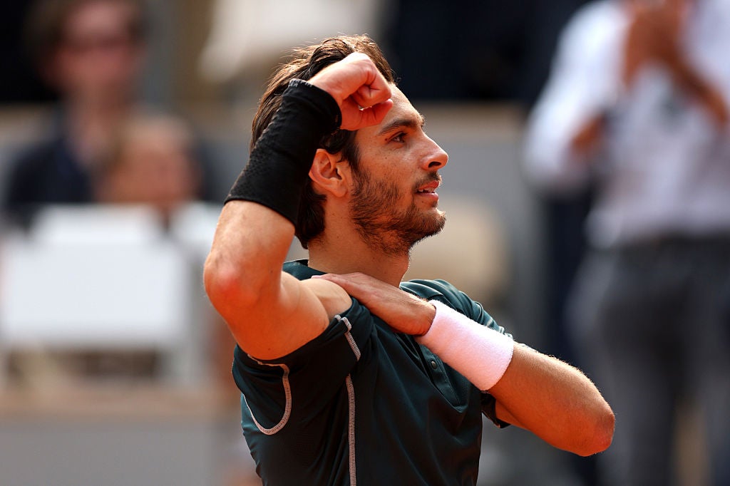 Musetti flexes his muscles after winning in four sets to reach the semis